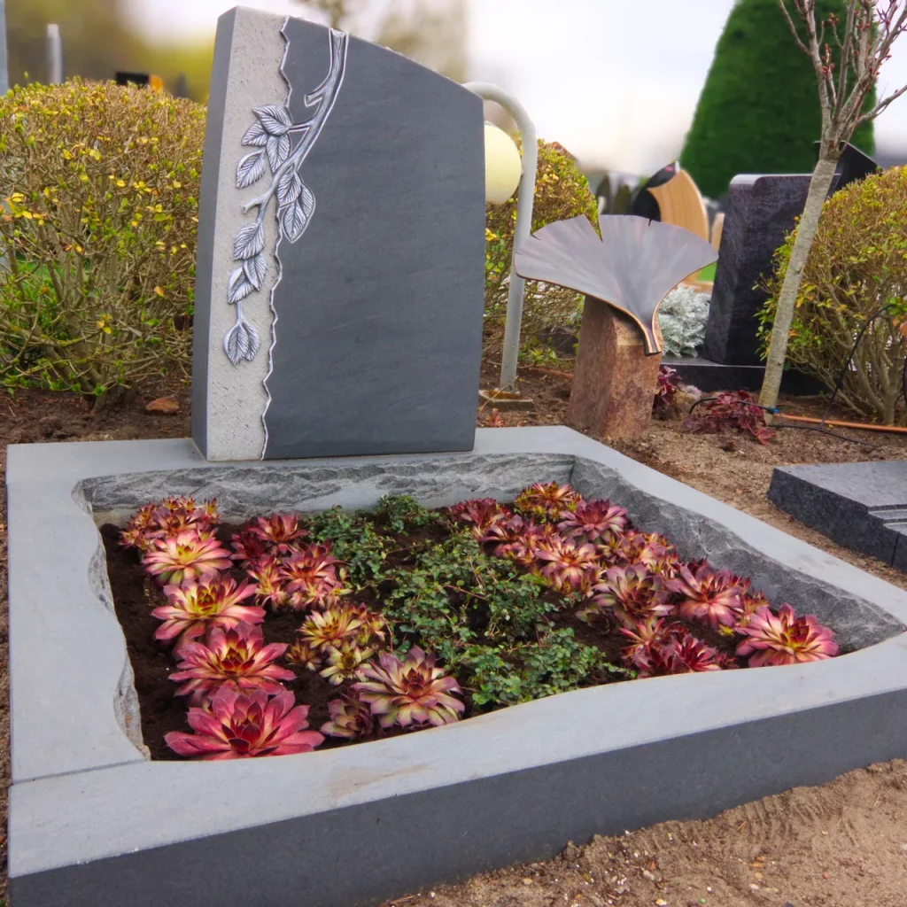 Urnengrabstein mit Einfassung und Bepflanzung